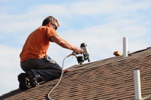 Roof edge showing vented soffit, painted fascia, attached gutter, and roof shingles on a residential home.