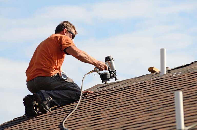 Roof edge showing vented soffit, painted fascia, attached gutter, and roof shingles on a residential home.